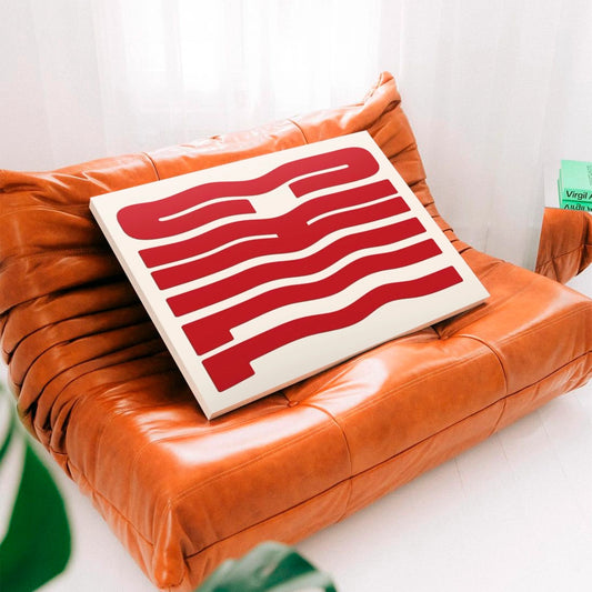 Cuadro en bastidor Chill Wave apoyado sobre un sofá de diseño en cuero en una sala contemporánea.