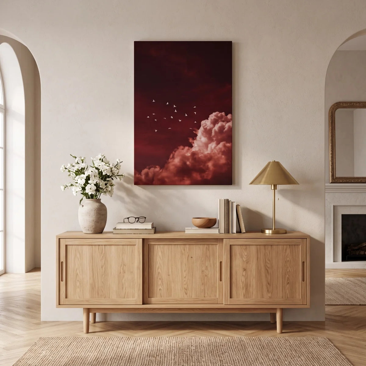 Cuadro de acento rojo colgado sobre una credenza de madera de roble claro en una sala contemporánea.