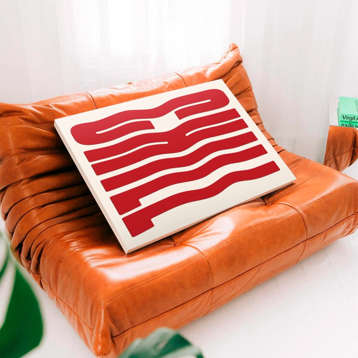 Cuadro en bastidor Chill Wave apoyado sobre un sofá de diseño en cuero en una sala contemporánea.