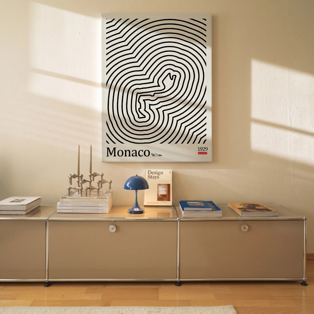 Cuadro decorativo del circuito de Mónaco apoyado sobre una credenza modular en una sala de estar moderna.