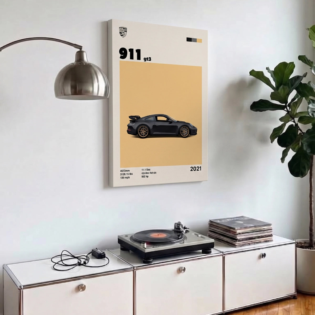 Cuadro de Porsche 911 GT3 en bastidor colgado sobre una credenza blanca en una sala contemporánea.