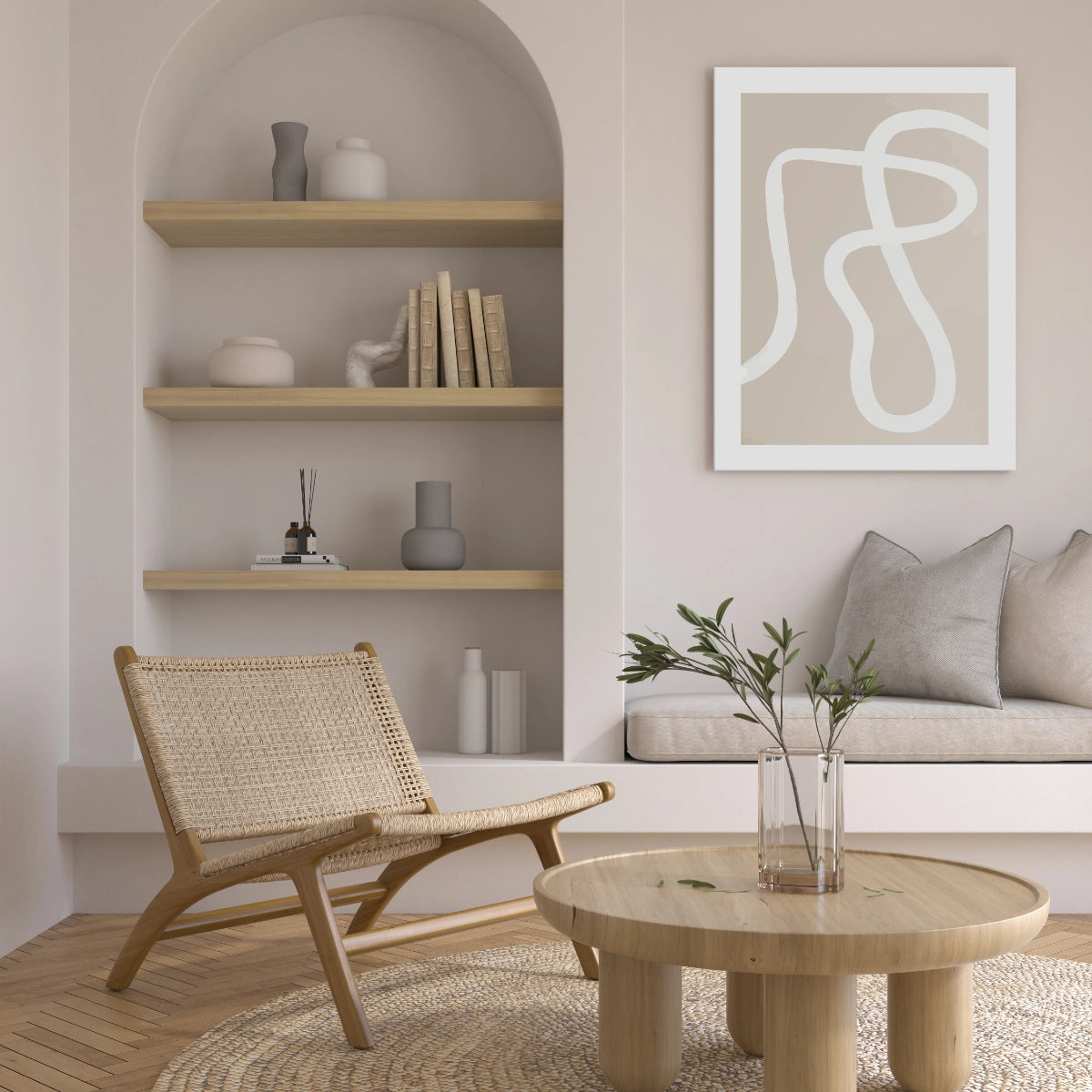 Cuadro decorativo en tonos neutros en una sala de estar iluminada junto a una silla de mimbre y mesa de madera.